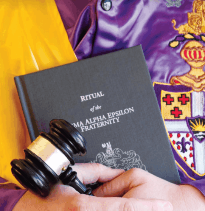 brother holding the ritual handbook with gavel