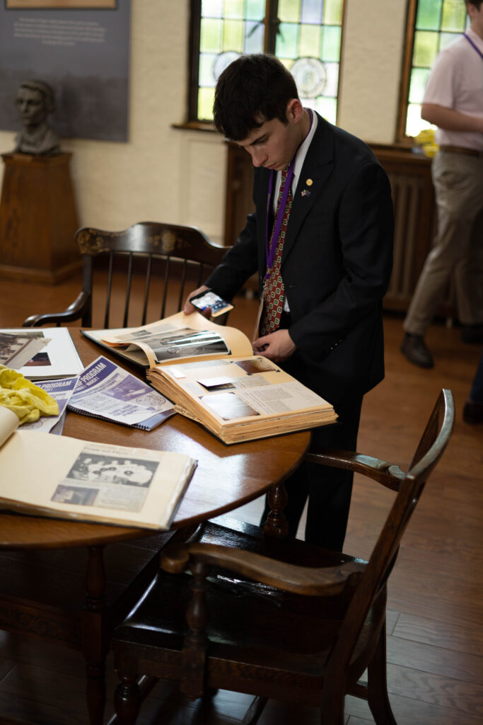 Sigma Alpha Epsilon brother reading a scrapbook in the library