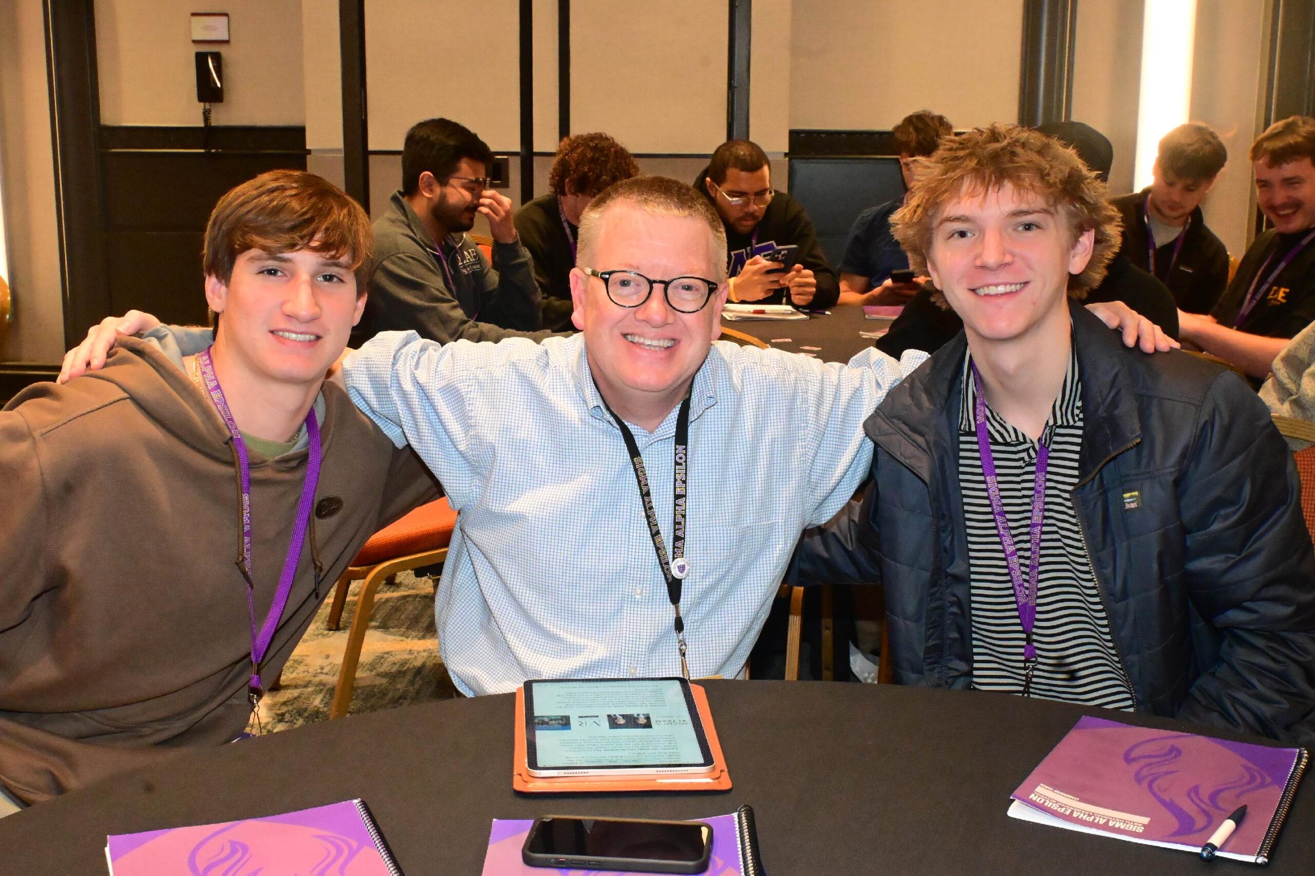 SAE brothers sitting at conference table