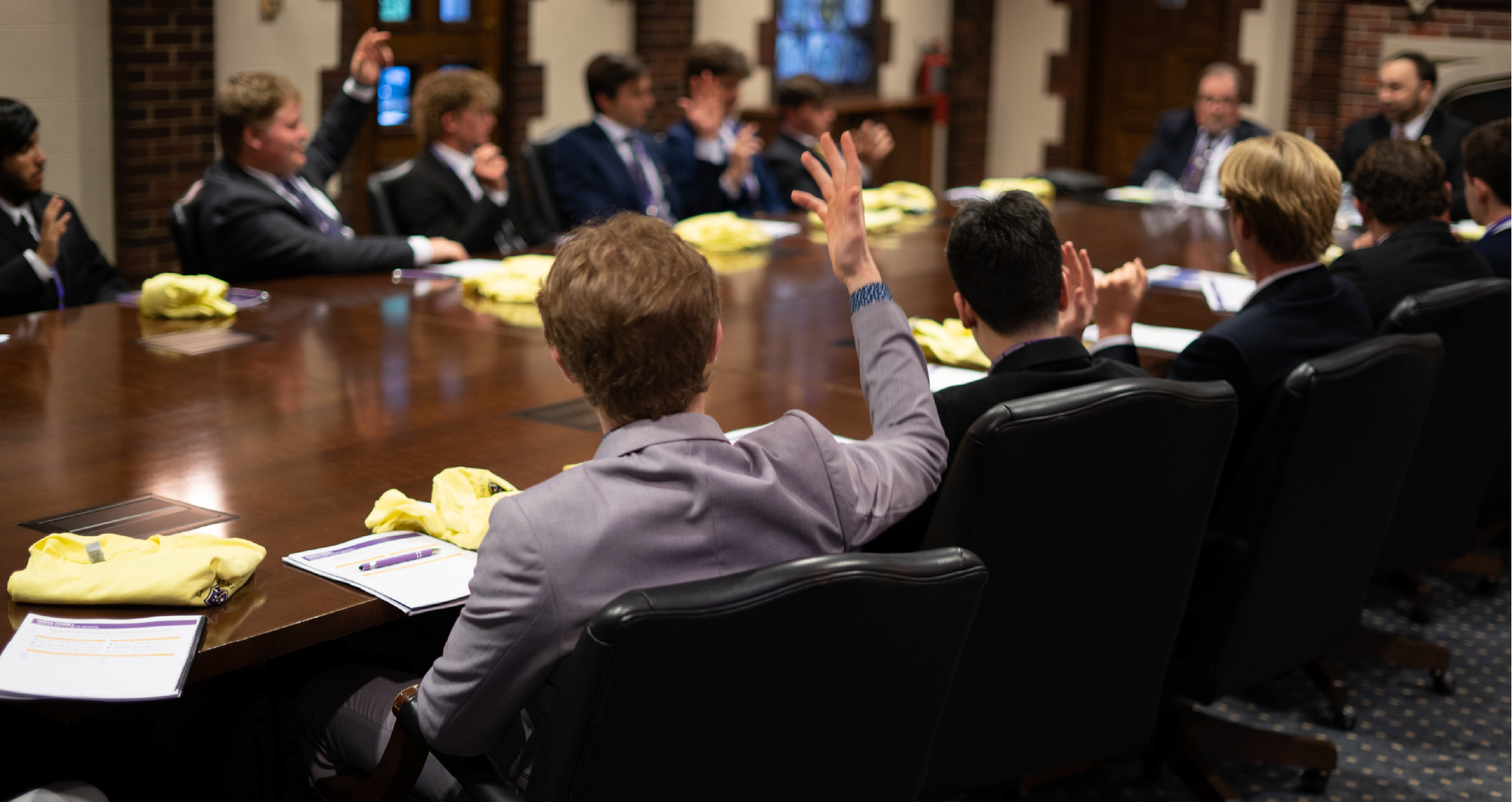 SAE brothers sitting at a long conference table